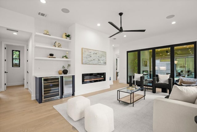 3005 French Pl, Austin, TX 78722 - living room with beverage cooler, ceiling fan, light wood-type flooring, recessed lighting, and a glass covered fireplace