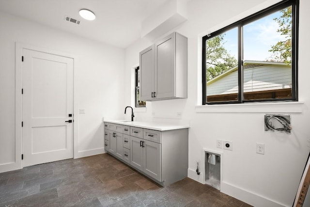 3005 French Pl, Austin, TX 78722 - laundry area with hookup for an electric dryer, cabinet space, and stone finish flooring