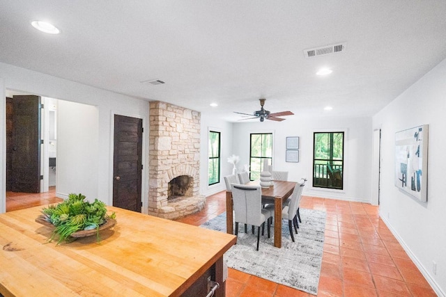 1703 Graywood Cv, Austin, TX 78704 - dining area with light tile patterned flooring, a stone fireplace, ceiling fan, and recessed lighting
