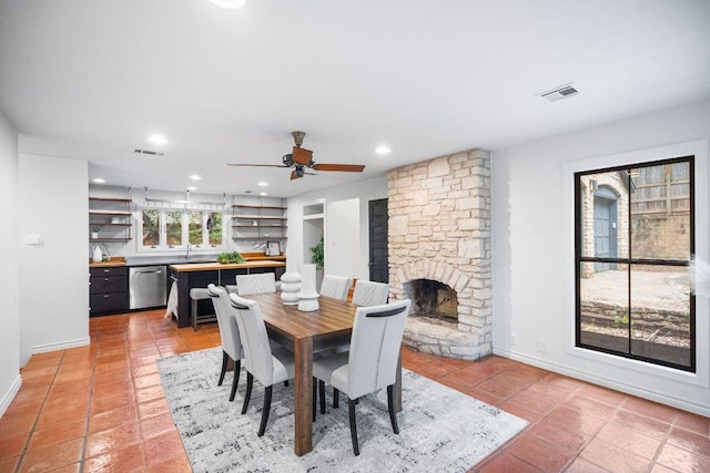 1703 Graywood Cv, Austin, TX 78704 - dining space with a stone fireplace, a ceiling fan, recessed lighting, light tile patterned floors, and built in shelves