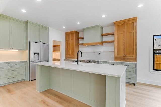837 Birch Ln, Cottonwood Shores, TX 78657 - kitchen with stainless steel refrigerator with ice dispenser, open shelves, light wood finished floors, light countertops, and a center island with sink