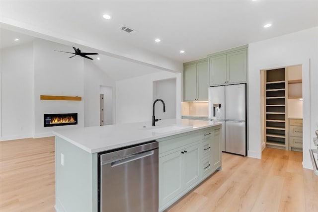 837 Birch Ln, Cottonwood Shores, TX 78657 - kitchen with stainless steel dishwasher, high quality fridge, light wood finished floors, light countertops, and an island with sink