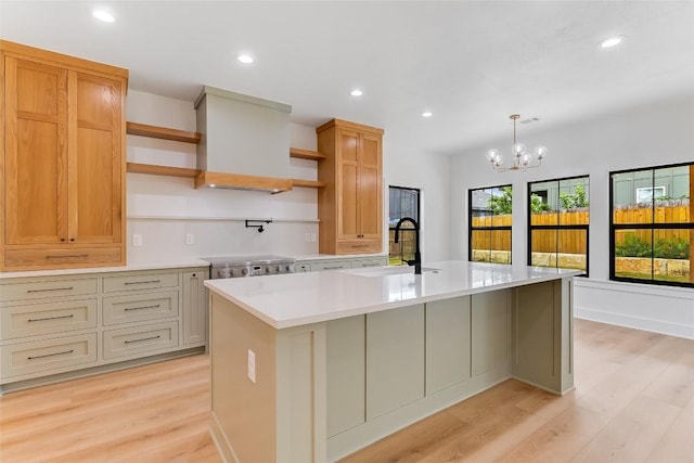 837 Birch Ln, Cottonwood Shores, TX 78657 - kitchen with open shelves, light countertops, light wood-style floors, custom exhaust hood, and a center island with sink