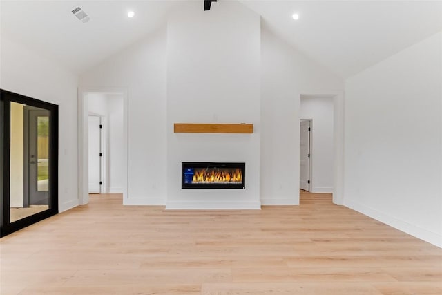 837 Birch Ln, Cottonwood Shores, TX 78657 - unfurnished living room with high vaulted ceiling, a glass covered fireplace, light wood finished floors, and recessed lighting