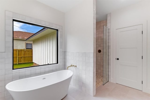 837 Birch Ln, Cottonwood Shores, TX 78657 - bathroom with tile walls, a soaking tub, a tile shower, and tile patterned flooring