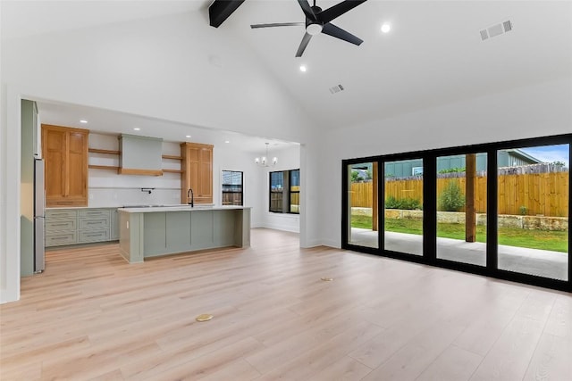 837 Birch Ln, Cottonwood Shores, TX 78657 - unfurnished living room featuring high vaulted ceiling, a chandelier, beamed ceiling, plenty of natural light, and a ceiling fan