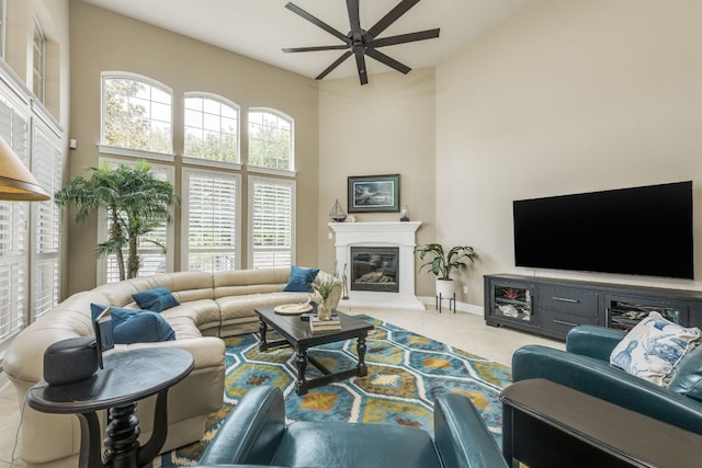 117 N Whitley Dr, Austin, TX 78738 - tiled living area featuring a ceiling fan, a towering ceiling, and a glass covered fireplace