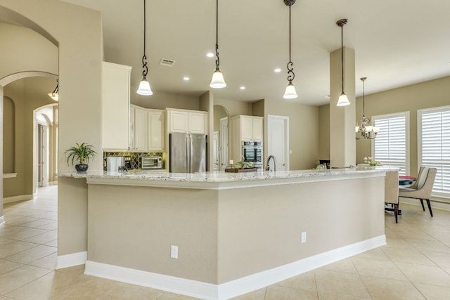 117 N Whitley Dr, Austin, TX 78738 - kitchen with stainless steel appliances, arched walkways, light tile patterned flooring, light stone counters, and recessed lighting