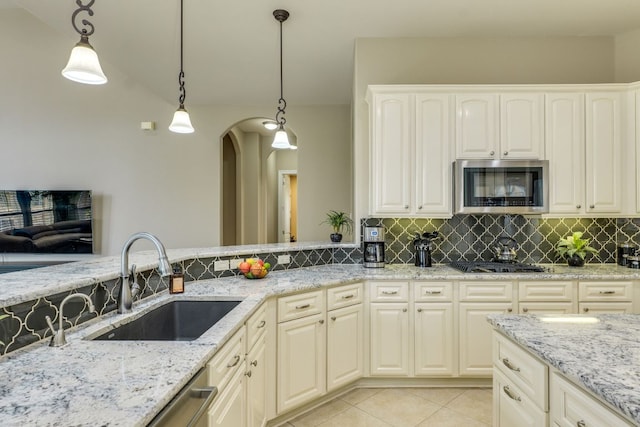 117 N Whitley Dr, Austin, TX 78738 - kitchen with appliances with stainless steel finishes, backsplash, arched walkways, light stone counters, and decorative light fixtures