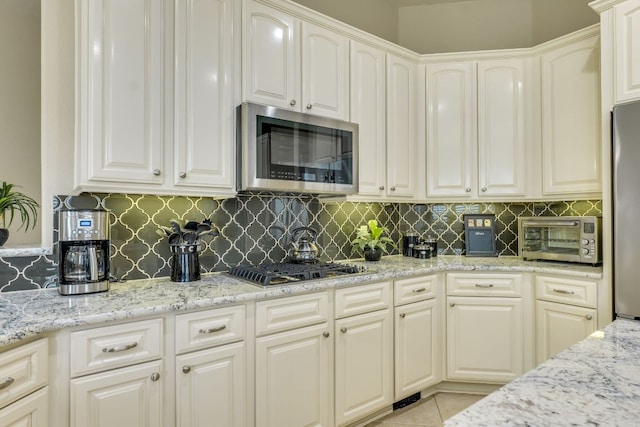 117 N Whitley Dr, Austin, TX 78738 - kitchen with stainless steel appliances, decorative backsplash, light stone counters, and white cabinetry