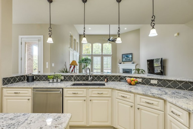 117 N Whitley Dr, Austin, TX 78738 - kitchen featuring stainless steel dishwasher, a ceiling fan, hanging light fixtures, light stone countertops, and a fireplace