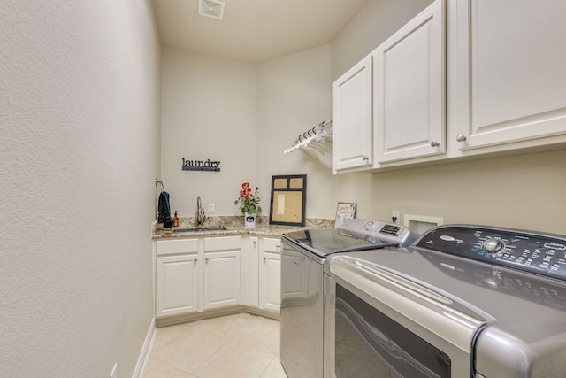 117 N Whitley Dr, Austin, TX 78738 - laundry area featuring independent washer and dryer, cabinet space, and light tile patterned floors