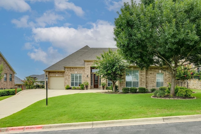 117 N Whitley Dr, Austin, TX 78738 - view of front of home featuring concrete driveway, an attached garage, a front yard, and brick siding