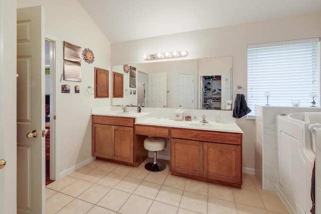 210 Buoy Cir, Georgetown, TX 78633 - bathroom with double vanity, lofted ceiling, tile patterned flooring, a spacious closet, and a tub