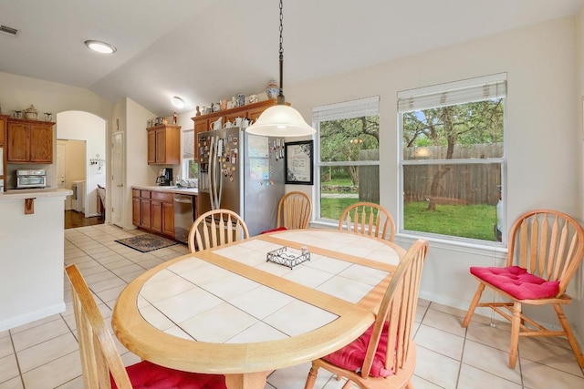 210 Buoy Cir, Georgetown, TX 78633 - dining space with separate washer and dryer, lofted ceiling, arched walkways, and light tile patterned floors