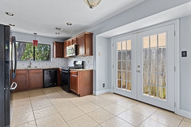 1102 Forest Oaks Path, Cedar Park, TX 78613 - kitchen featuring black appliances, french doors, tasteful backsplash, a textured ceiling, and pendant lighting