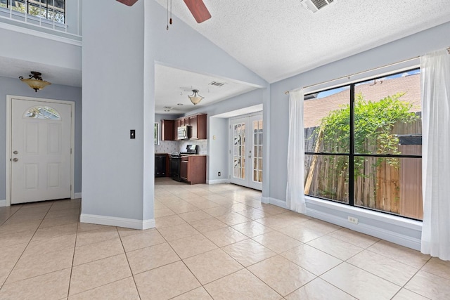 1102 Forest Oaks Path, Cedar Park, TX 78613 - unfurnished living room with light tile patterned flooring, ceiling fan, lofted ceiling, a textured ceiling, and french doors