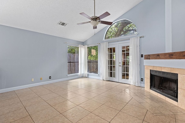 1102 Forest Oaks Path, Cedar Park, TX 78613 - unfurnished living room with french doors, tile patterned floors, ceiling fan, a textured ceiling, and a tiled fireplace