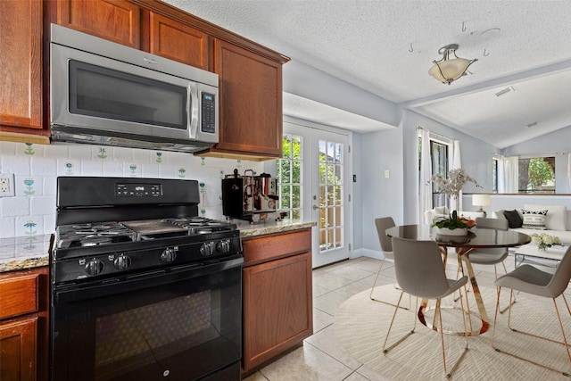 1102 Forest Oaks Path, Cedar Park, TX 78613 - kitchen with black range with gas cooktop, stainless steel microwave, tasteful backsplash, plenty of natural light, and lofted ceiling
