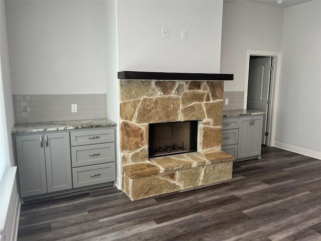 108 W Keamuku Ct, Bastrop, TX 78602 - detailed view of wood finished floors, backsplash, and a stone fireplace