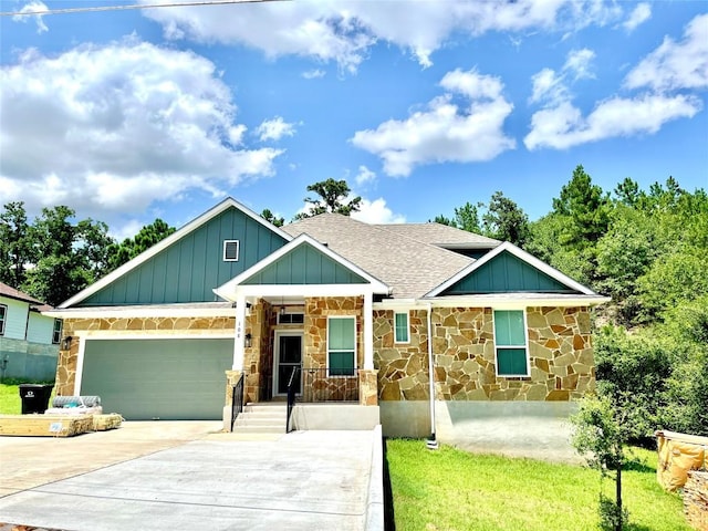 108 W Keamuku Ct, Bastrop, TX 78602 - view of front of house with stone siding, a shingled roof, concrete driveway, board and batten siding, and an attached garage