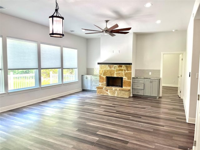 108 W Keamuku Ct, Bastrop, TX 78602 - unfurnished living room with ceiling fan, a stone fireplace, recessed lighting, and dark wood finished floors