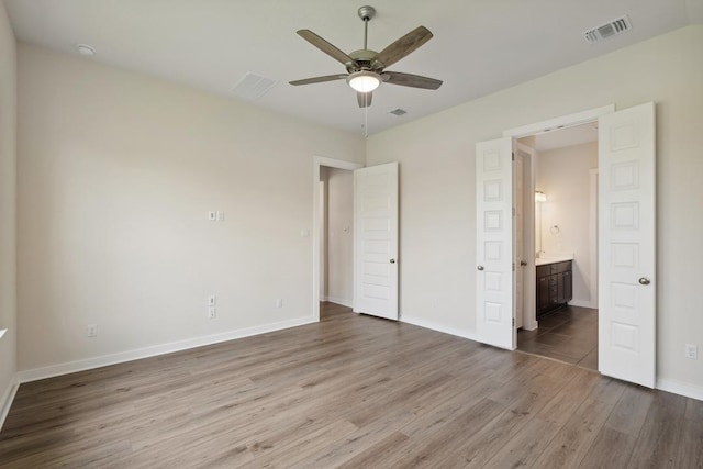 1754 Sawmill Xing, Round Rock, TX 78665 - unfurnished bedroom with wood finished floors, ensuite bath, and a ceiling fan