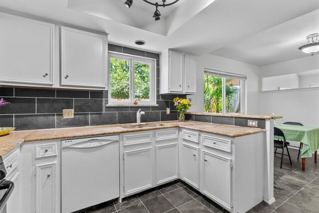 1305 Doonesbury Dr, Austin, TX 78758 - kitchen with dishwasher, a peninsula, white cabinetry, tasteful backsplash, and dark tile patterned flooring