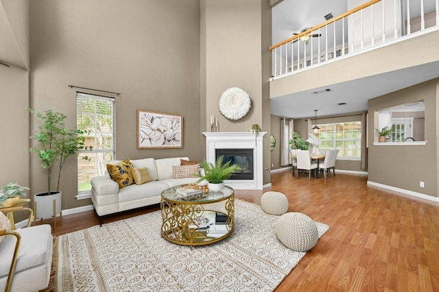 8305 Hillrock Dr, Round Rock, TX 78681 - living room with a high ceiling, plenty of natural light, wood finished floors, and a glass covered fireplace