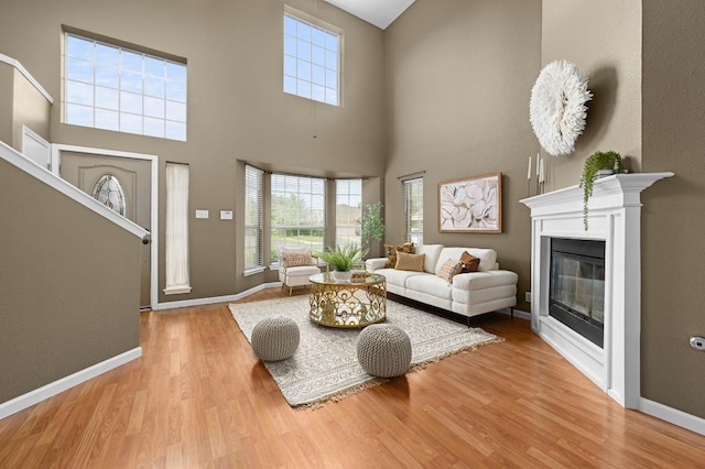 8305 Hillrock Dr, Round Rock, TX 78681 - living area with wood finished floors, a glass covered fireplace, and a towering ceiling
