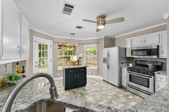 8305 Hillrock Dr, Round Rock, TX 78681 - kitchen featuring appliances with stainless steel finishes, tasteful backsplash, white cabinets, and crown molding