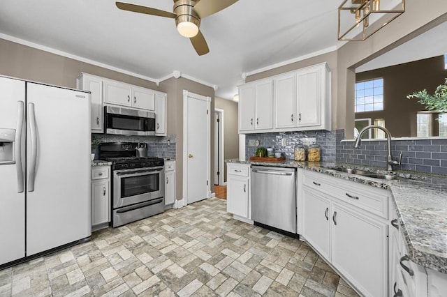 8305 Hillrock Dr, Round Rock, TX 78681 - kitchen with stainless steel appliances, a ceiling fan, decorative backsplash, white cabinetry, and ornamental molding
