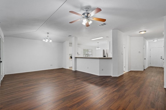 2012 Charlotte Way, Round Rock, TX 78664 - unfurnished living room featuring a chandelier, a ceiling fan, and dark wood-style floors
