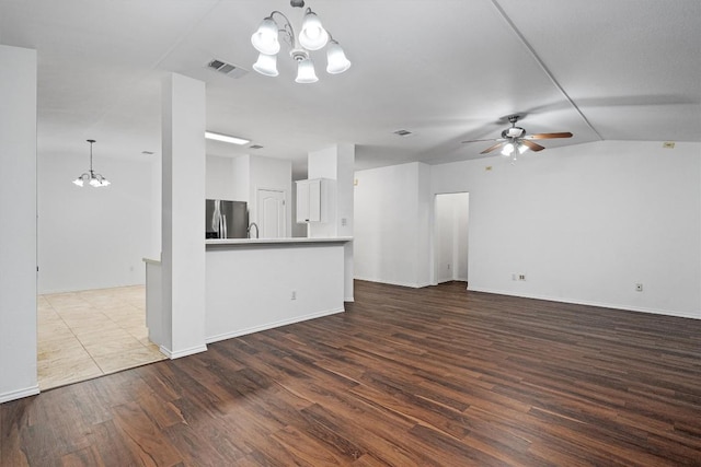 2012 Charlotte Way, Round Rock, TX 78664 - unfurnished living room featuring a chandelier, dark wood-style flooring, a ceiling fan, and vaulted ceiling