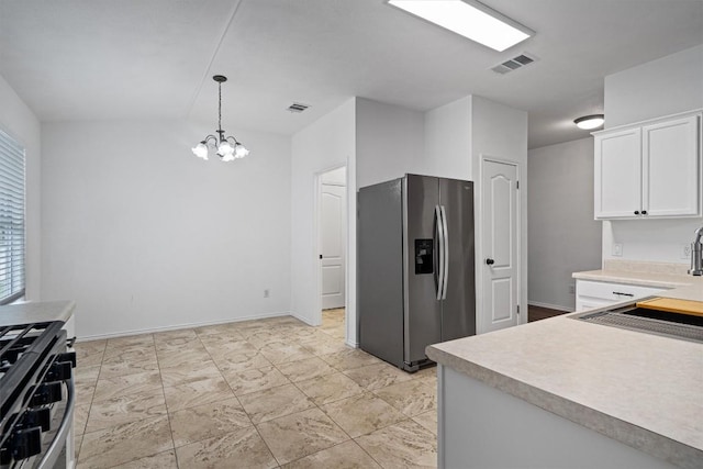 2012 Charlotte Way, Round Rock, TX 78664 - kitchen with stainless steel appliances, a chandelier, light countertops, and white cabinetry
