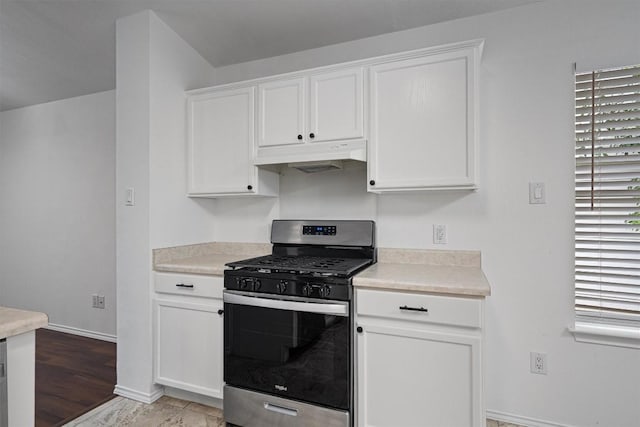2012 Charlotte Way, Round Rock, TX 78664 - kitchen with stainless steel range with gas cooktop, under cabinet range hood, white cabinetry, light countertops, and light wood-style floors