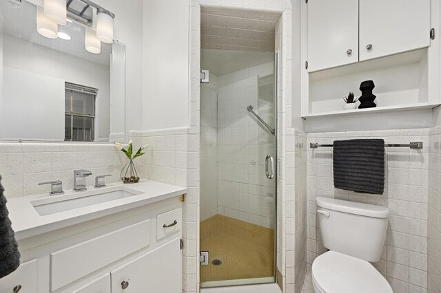 2110 Bluebonnet Ln, Austin, TX 78704 - full bathroom with tile walls, vanity, a stall shower, and wainscoting