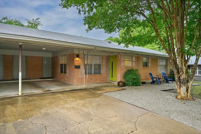 2110 Bluebonnet Ln, Austin, TX 78704 - view of front of house featuring a carport, brick siding, concrete driveway, and roof with shingles