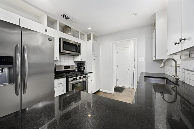 2110 Bluebonnet Ln, Austin, TX 78704 - kitchen featuring appliances with stainless steel finishes, tasteful backsplash, white cabinets, dark stone counters, and recessed lighting