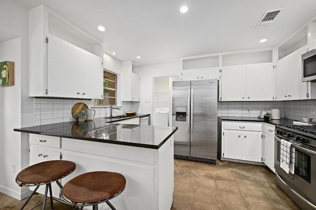 2110 Bluebonnet Ln, Austin, TX 78704 - kitchen with stainless steel appliances, decorative backsplash, dark countertops, a peninsula, and recessed lighting