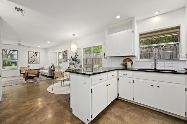 2110 Bluebonnet Ln, Austin, TX 78704 - kitchen with concrete floors, backsplash, a peninsula, dark countertops, and recessed lighting
