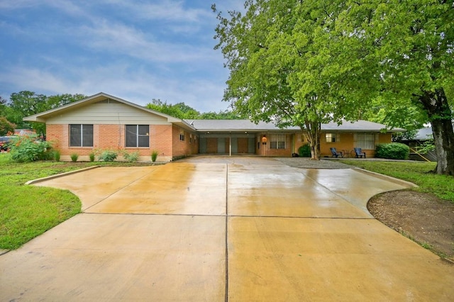 2110 Bluebonnet Ln, Austin, TX 78704 - ranch-style house with concrete driveway, brick siding, and a front yard