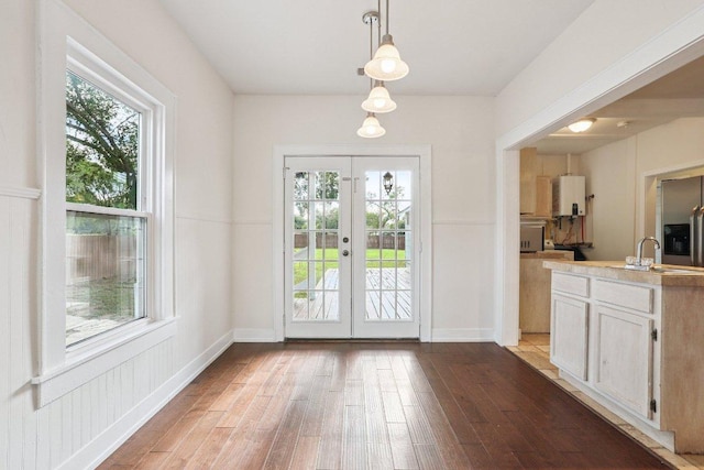 1916 Pecan St, Bastrop, TX 78602 - doorway to outside with plenty of natural light, wood finished floors, french doors, and water heater