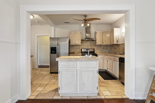 1916 Pecan St, Bastrop, TX 78602 - kitchen featuring stainless steel appliances, wall chimney exhaust hood, light countertops, a center island with sink, and stone tile flooring
