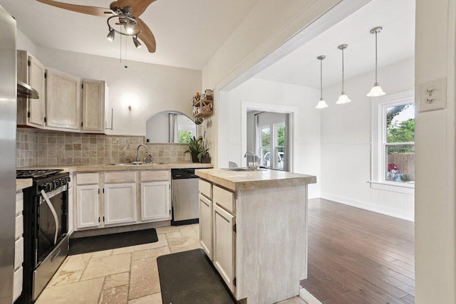 1916 Pecan St, Bastrop, TX 78602 - kitchen featuring gas stove, dishwasher, light countertops, ceiling fan, and wainscoting