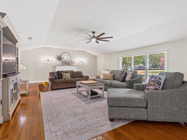 living room with ceiling fan, wood finished floors, and lofted ceiling