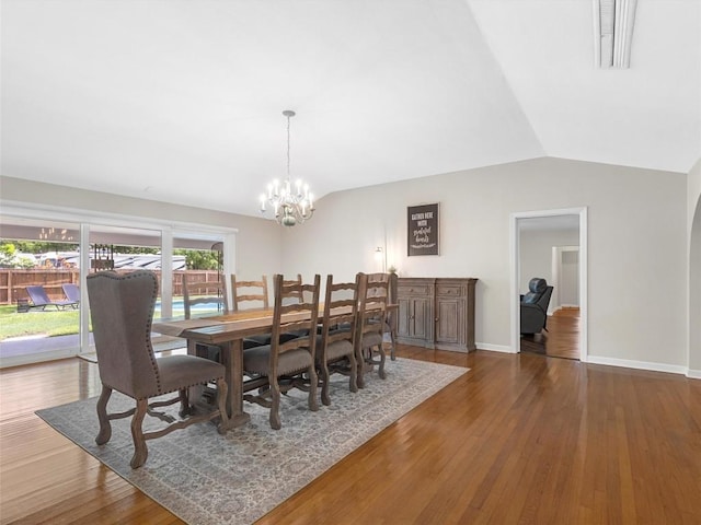 dining room with lofted ceiling, a chandelier, and wood finished floors