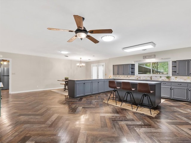 kitchen with open shelves, gray cabinets, healthy amount of natural light, and a breakfast bar