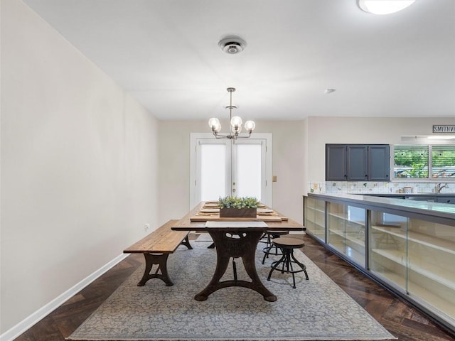 dining room with a chandelier and baseboards