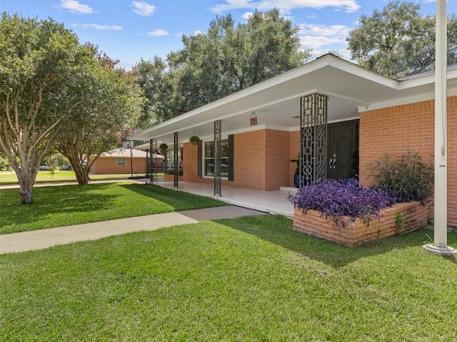 view of front of house with brick siding and a front lawn